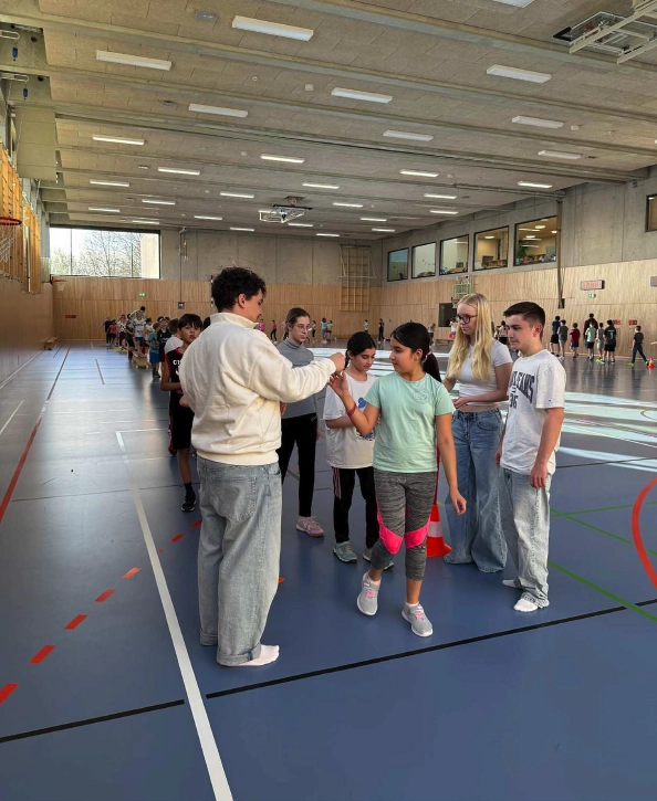 Kinder und Jugendliche in einer Sporthalle bei einem Spendenlauf.